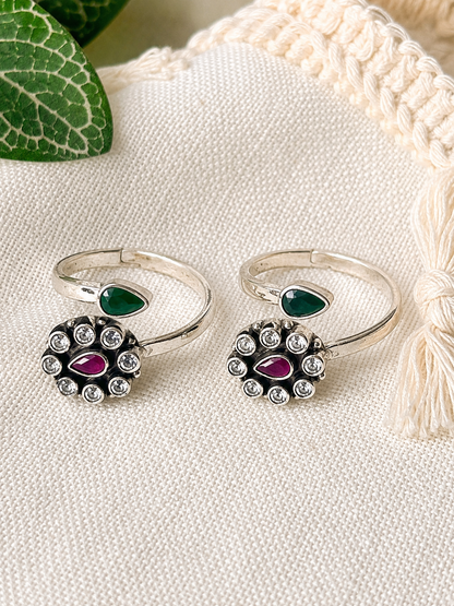925 silver oxidized floral cluster toe ring pair with green leaf accent on linen fabric