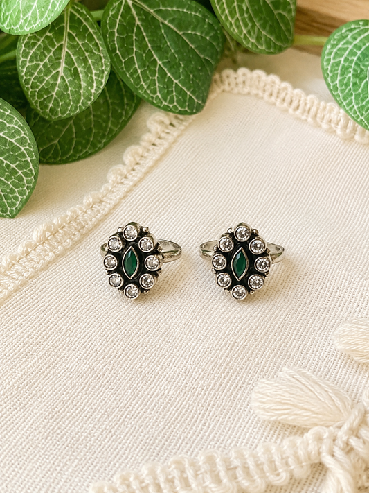 925 silver oxidized oval cluster toe ring pair with green stone on linen fabric