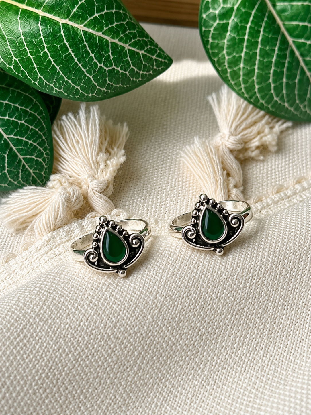 925 silver oxidized teardrop toe ring pair with green stone on tassel fabric