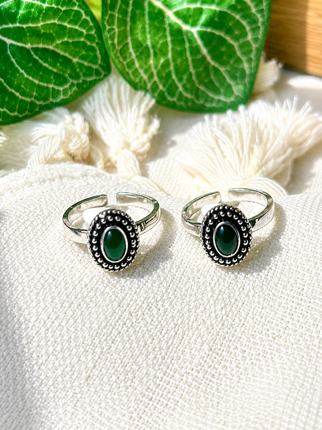 925 silver oxidized toe ring pair with oval green stone on tassel fabric