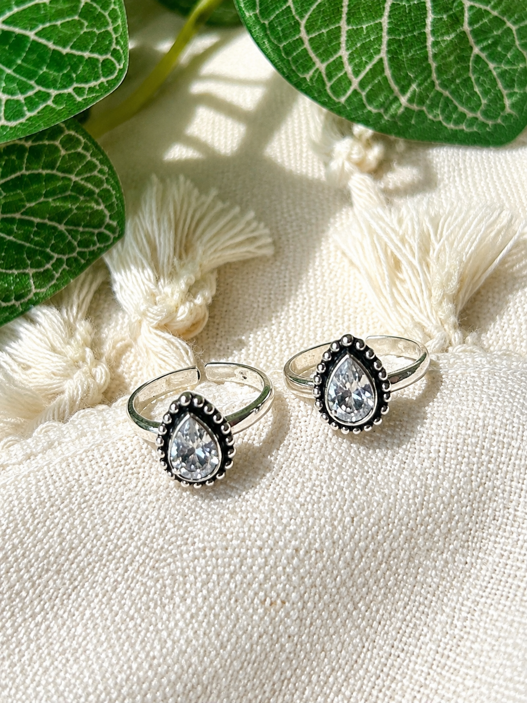 925 silver oxidized teardrop toe ring pair with clear stone on tassel fabric