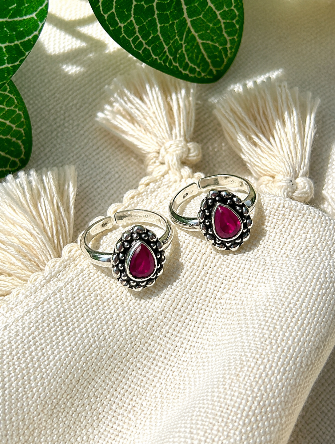 925 silver oxidized teardrop toe ring pair with magenta stone on tassel fabric