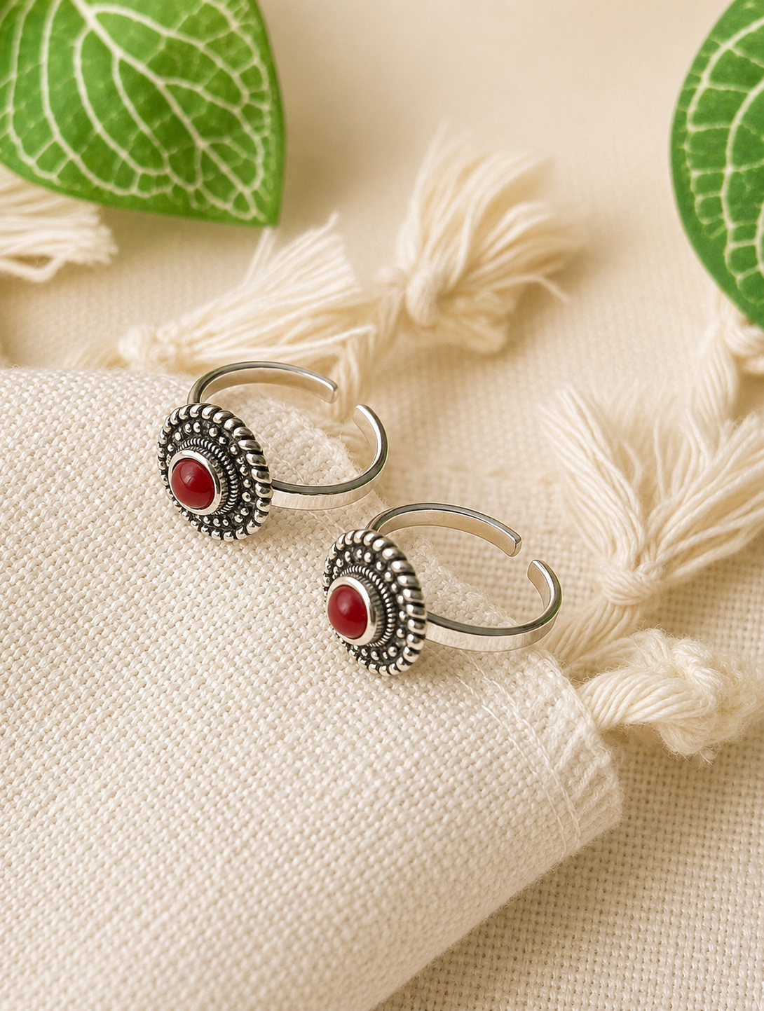 925 silver oxidized toe ring pair with coral-red stone on tassel fabric